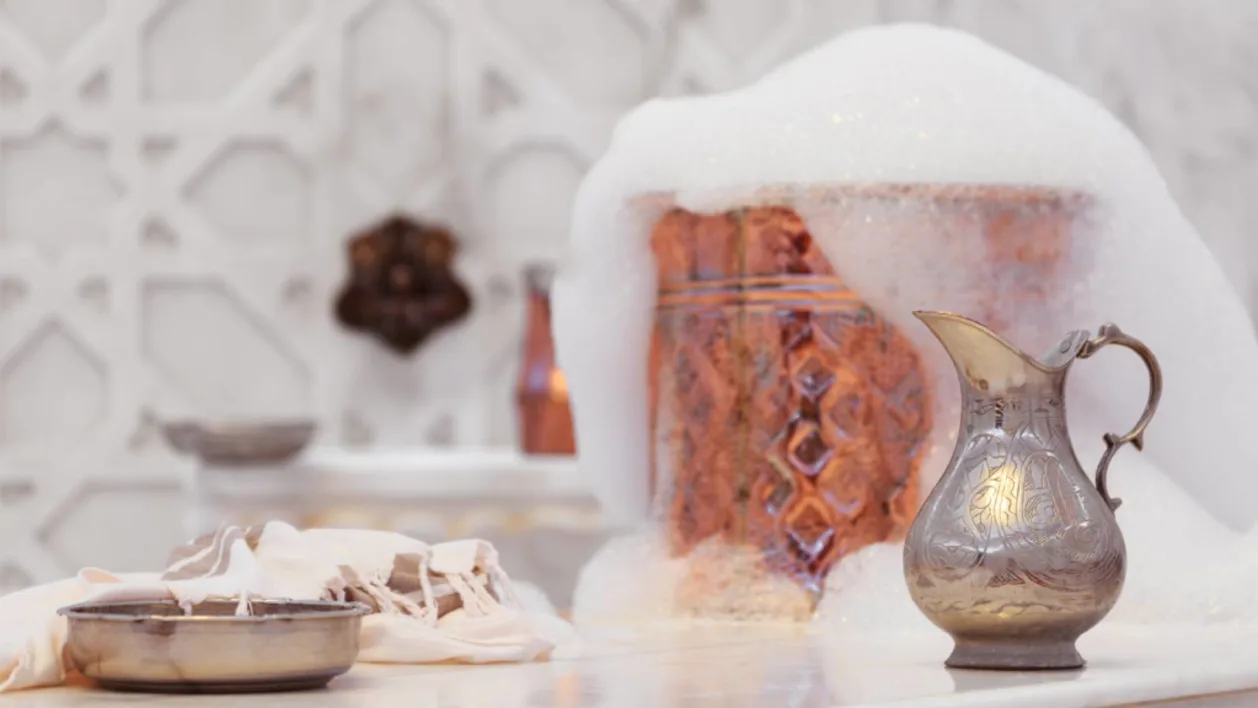 Water jar, towel and copper bowl with soap foam in authentic hammam